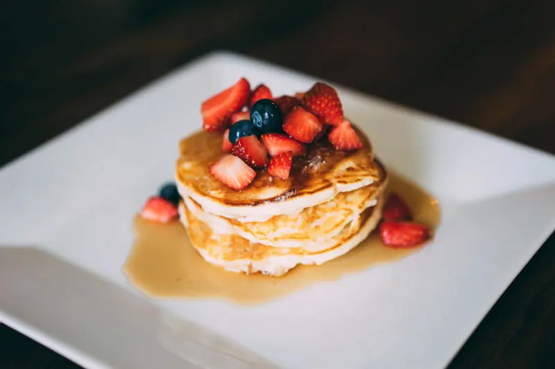 Stack of pancakes with berries and syrup