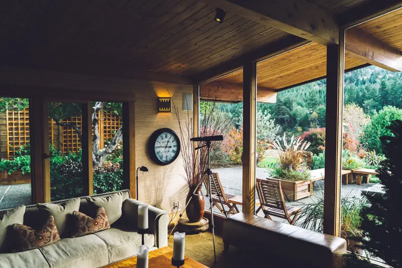 Screened porch with sofa and garden view