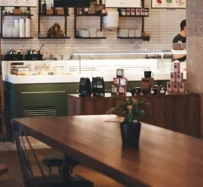 A cafe interior with a long wooden table