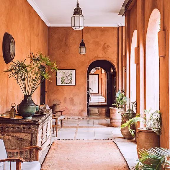 Warm painted hallway with arches and plants